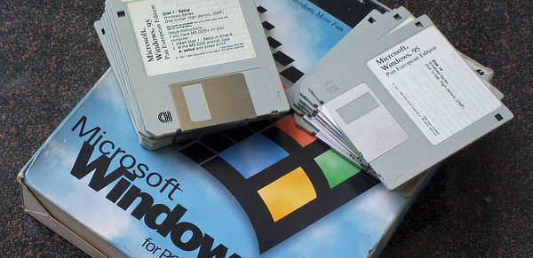 An old Windows 95 big box with several installer floppy disks stacked on top